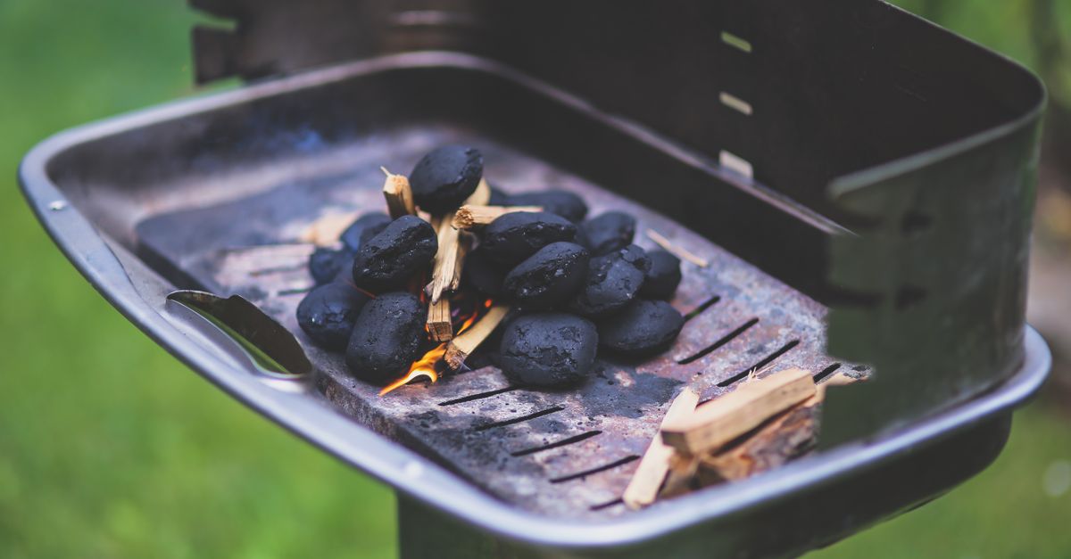 Brasas encendidas con carbón y leña en una parrilla al aire libre